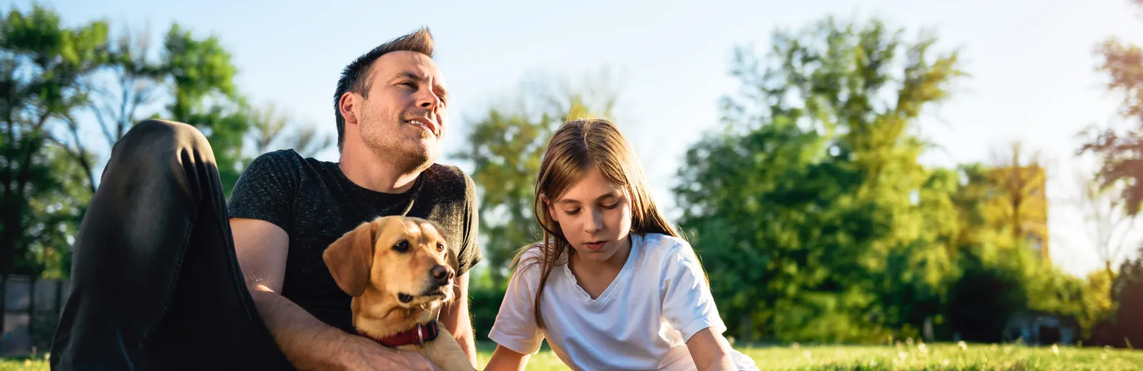 Family spending time sitting in green, healthy grass